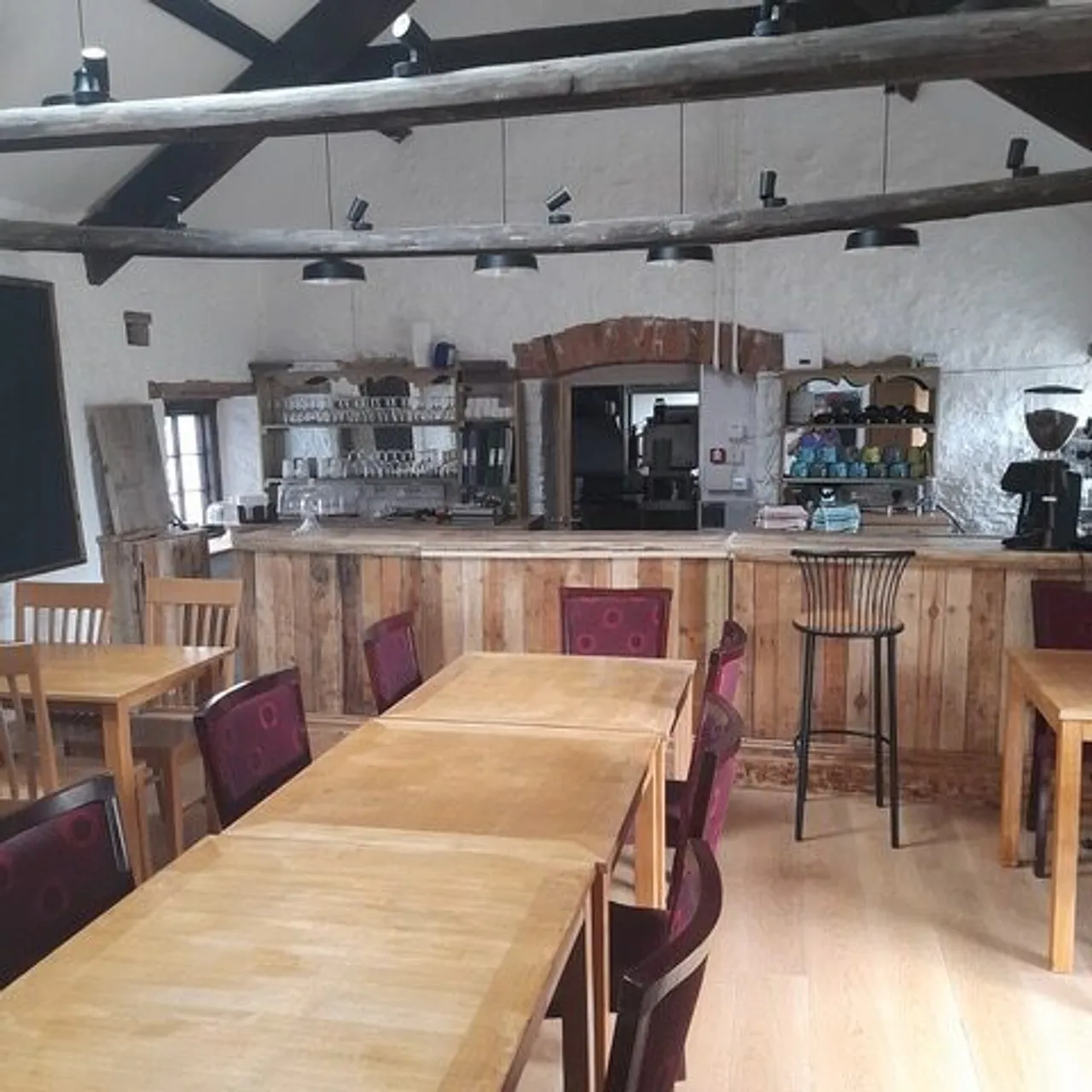 The timber beams, stone walls and wooden tables inside the Hub & Café